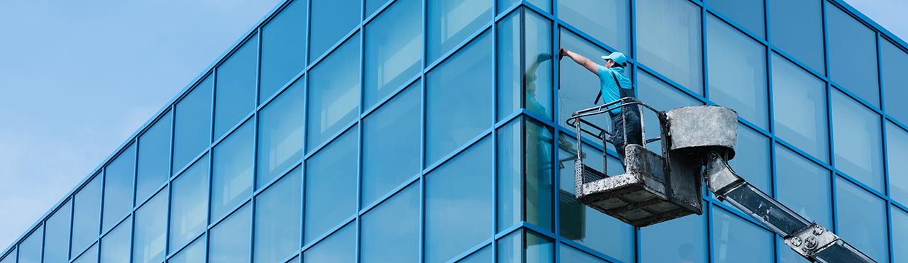 Window washer washes high windows.