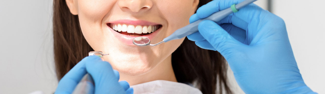 Woman's teeth checked by dentist
