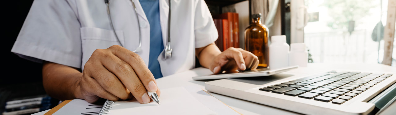 Doctor sits at his desk and updates his administration.
