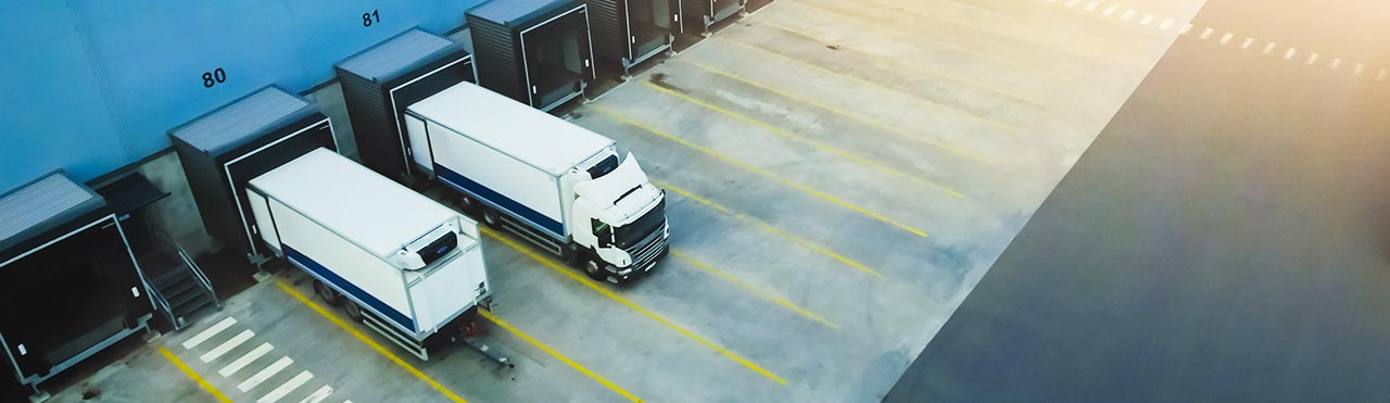 Trucks stand at loading bays of a logistics company.