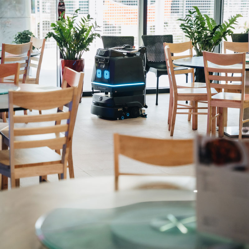 R3 cleaning robot cleans between tables and chairs